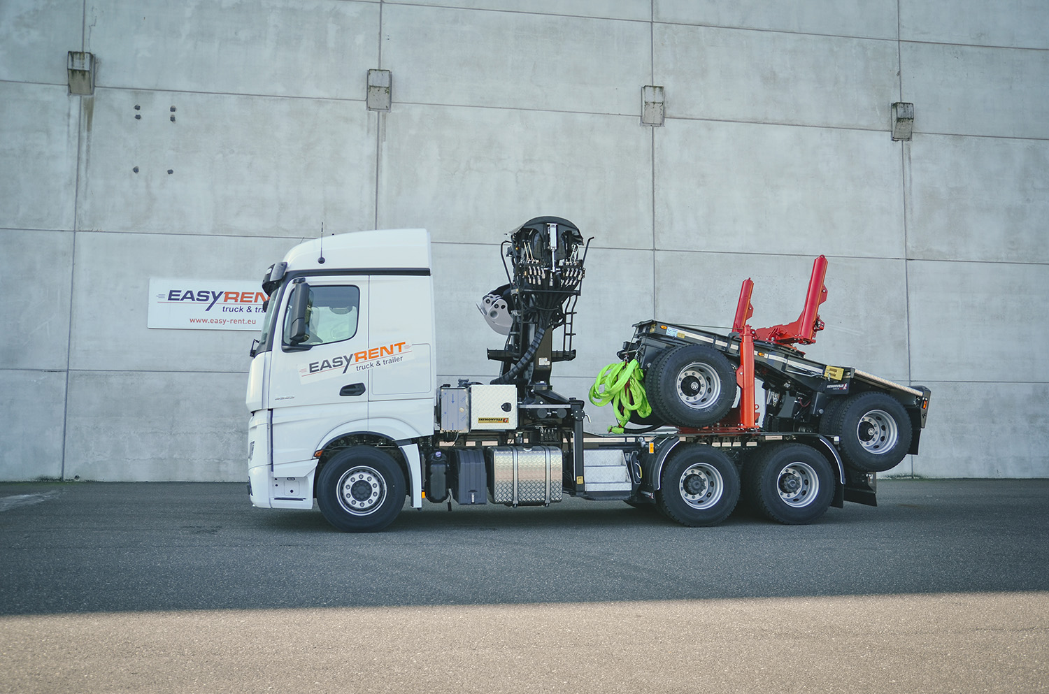 Easy Rent Faymonville FlexMAX houtvrachtwagen zonder lading op parkeerplaats voor grijze muur