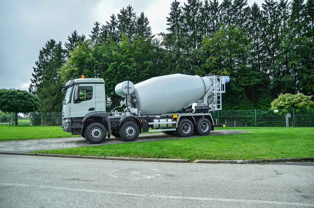 Vordere Seitenansicht eines weißen Betonfahrmischers Mercedes-Benz Arocs 3740B 8x4 Stetter AM-10-FHC Basic-Line