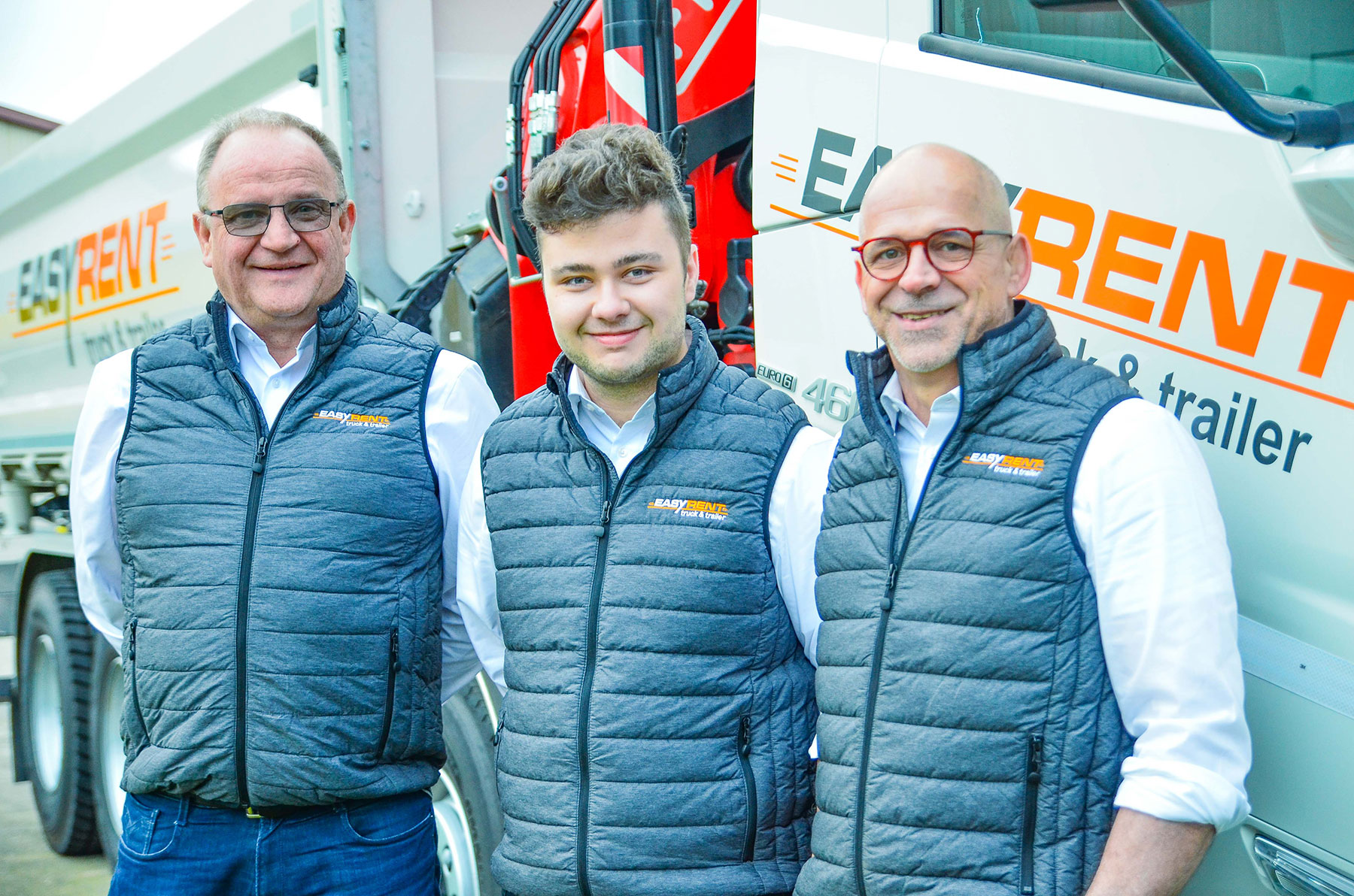 The sales team of Easy Rent truck & trailer Belgium and Luxembourg. Marc Halmes, Patrick Hoffmann and Olivier Marquet. Group photo in front of an Easy Rent crane vehicle