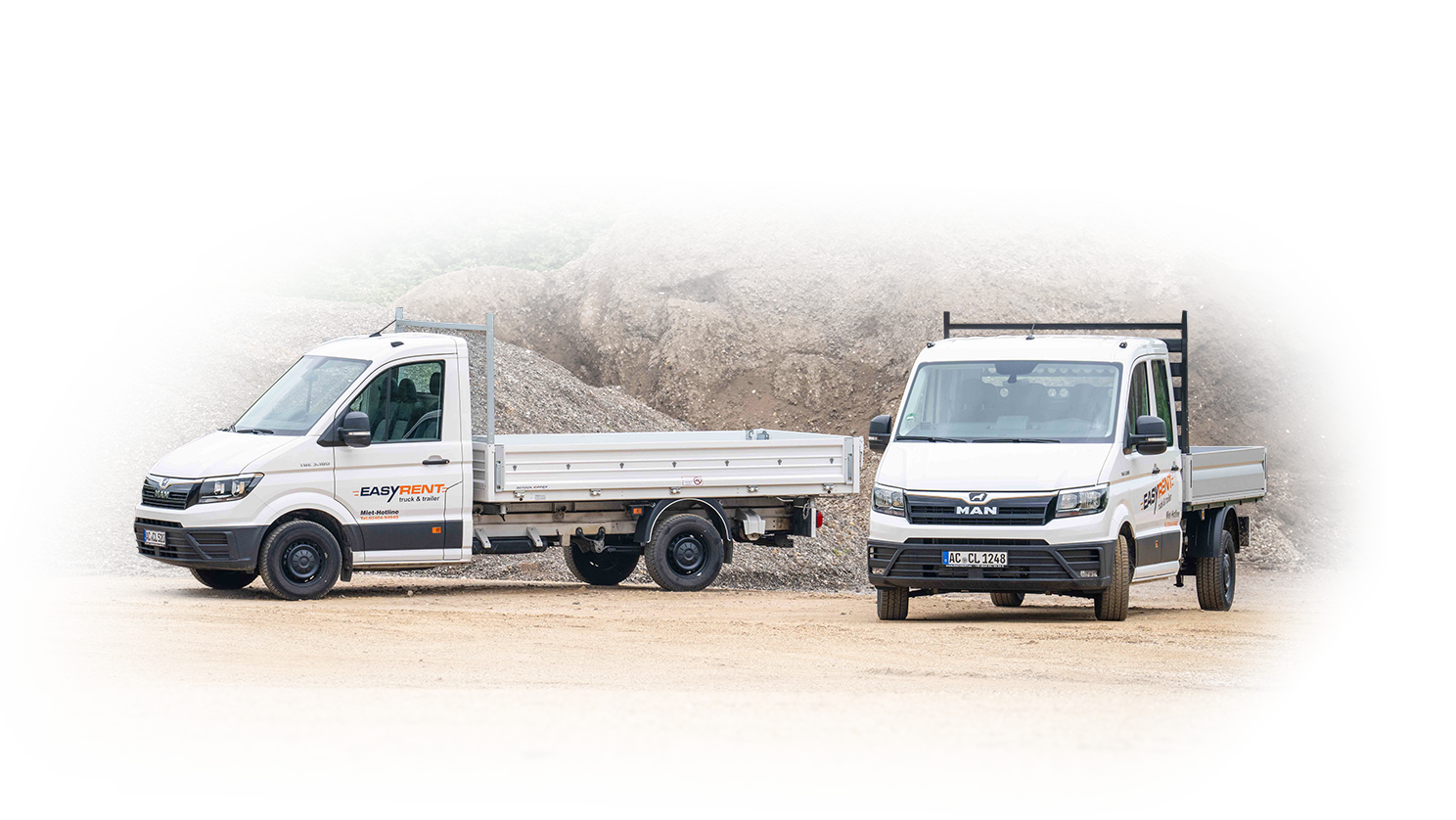 Auch kleine Transporter stehen zur Miete im Furhpark bei Easy Rent truck & trailer für euch bereit. Auf diesem Bild sind zwei MAN Transporter mit Pritsche zu sehen.