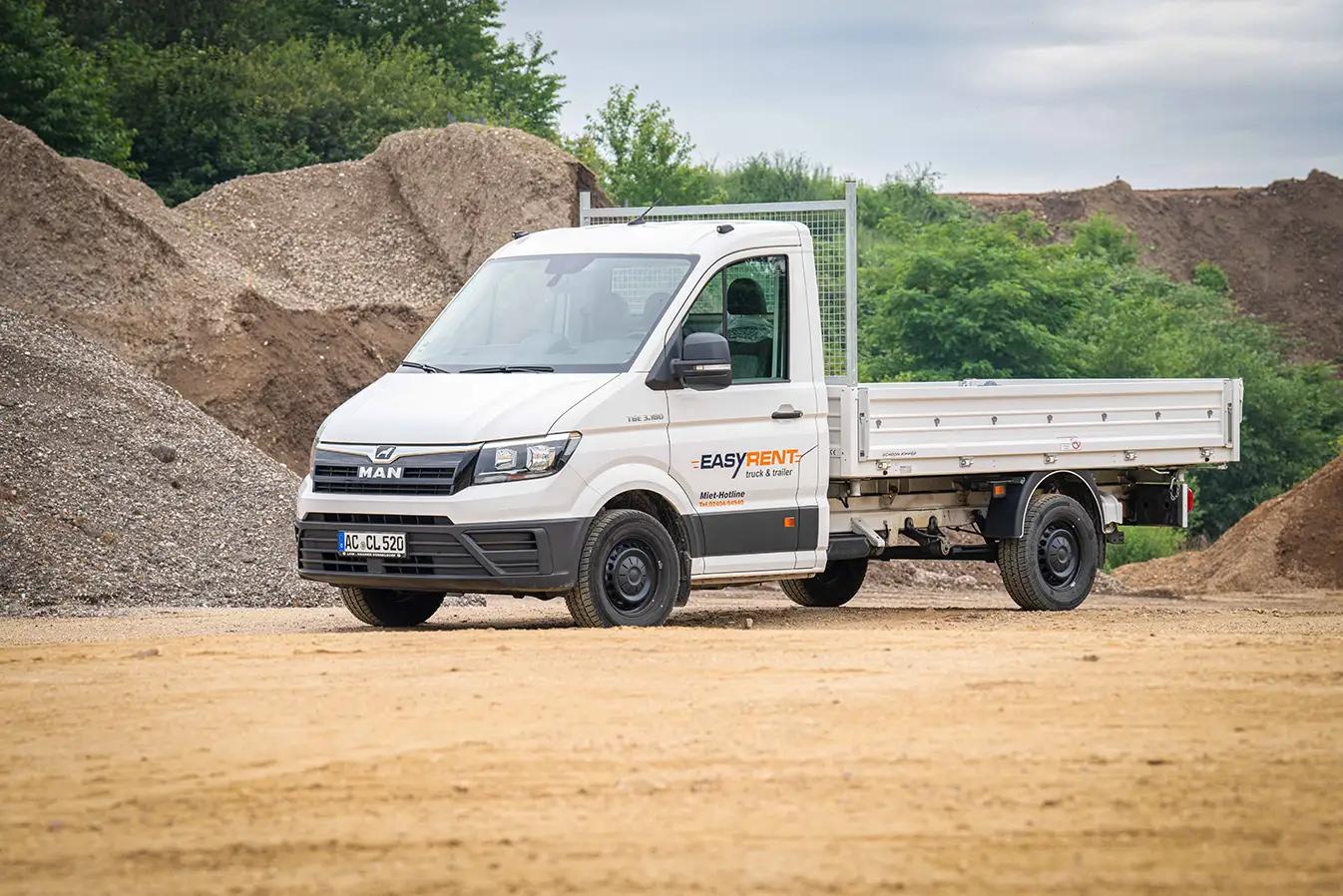Side view of a white MAN TGE 4x2 transporter three-way tipper on a construction site
