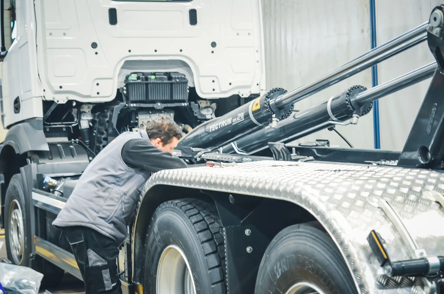 Werkstattmitarbeiter bei Arbeiten an einem Meiller Abrollkipper