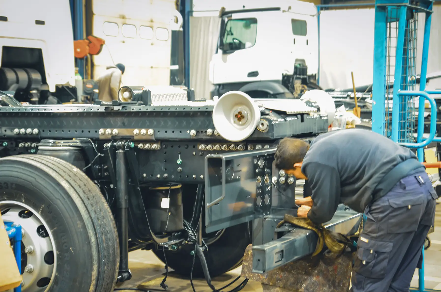 Mitarbeiter bei Installation von hydraulischer Stoßstange an einem Abrollkipper