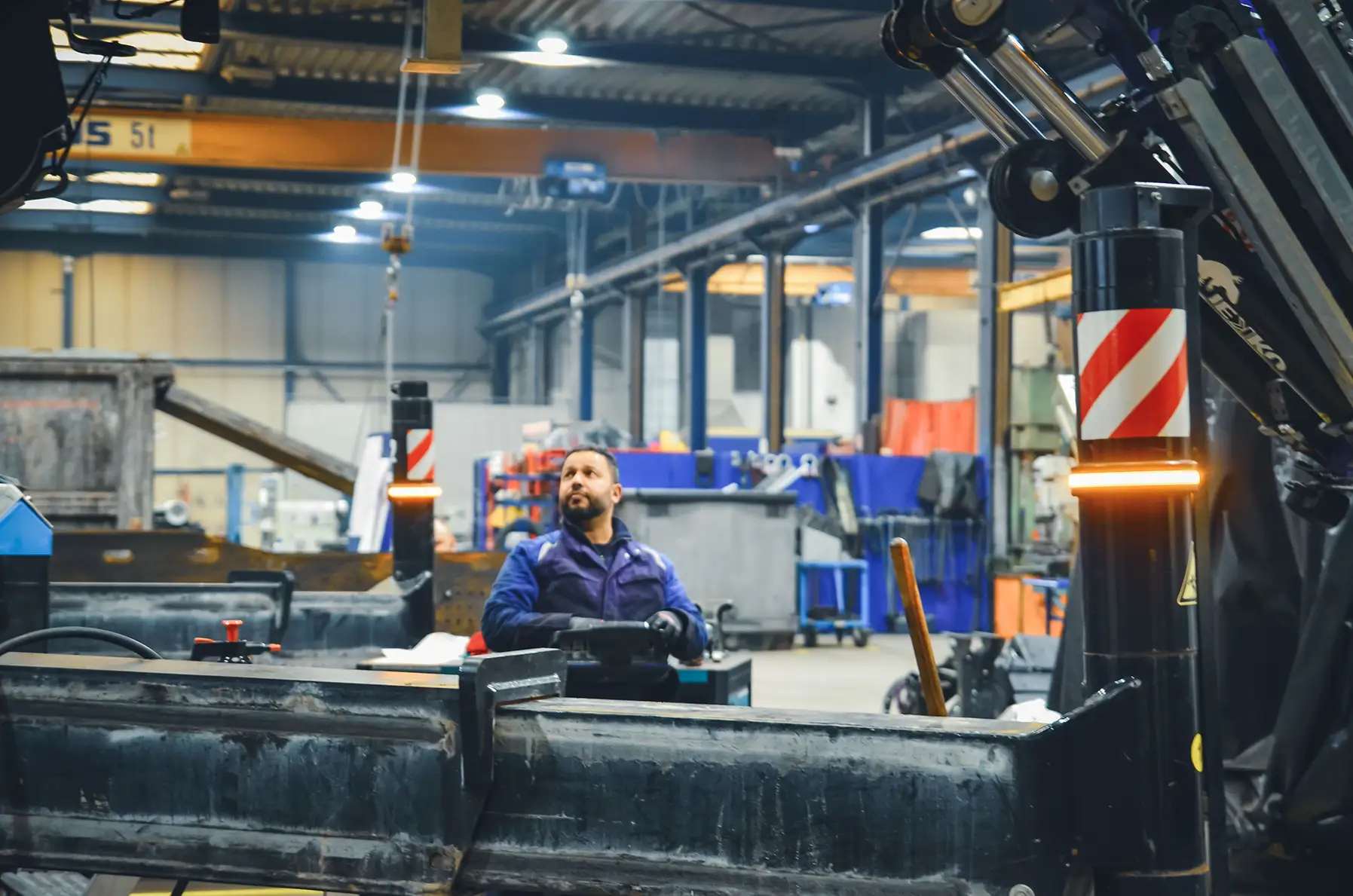 Mitarbeiter der Werkstatt bei der Bedienung eines Krans mit Funkfernbedienung