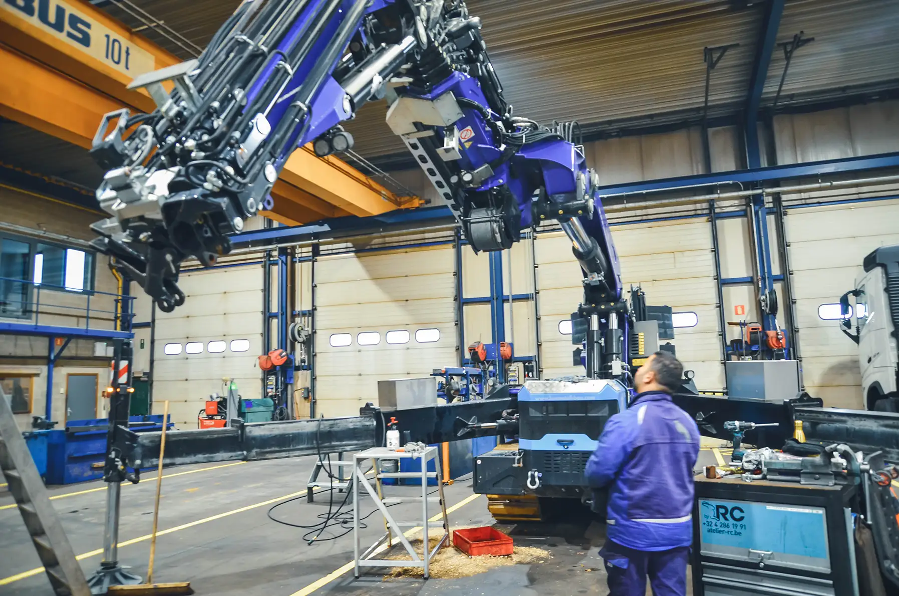 Werkstattmitarbeiter bei Unterhaltsarbeiten an einem Ladekran