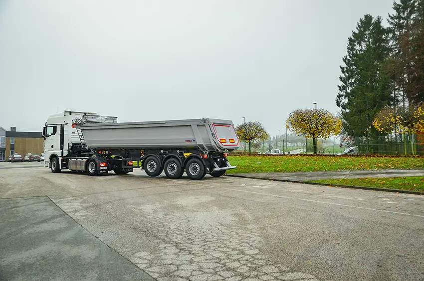 White tractor unit combined with a Schmitz Cargobull SKI 3-axle steel tipper