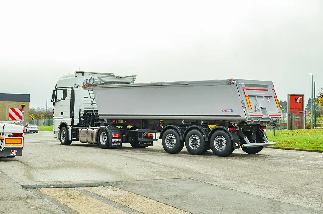 Combination of white 4x2 tractor unit with a Schmitz Cargobull 3-axle aluminum tipper trailer